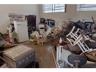 LOTE 001 - Composto por mesa e cadeiras escolares, caixas, armários de metal, geladeira, fogões, televisores, ventiladores, entre outros.